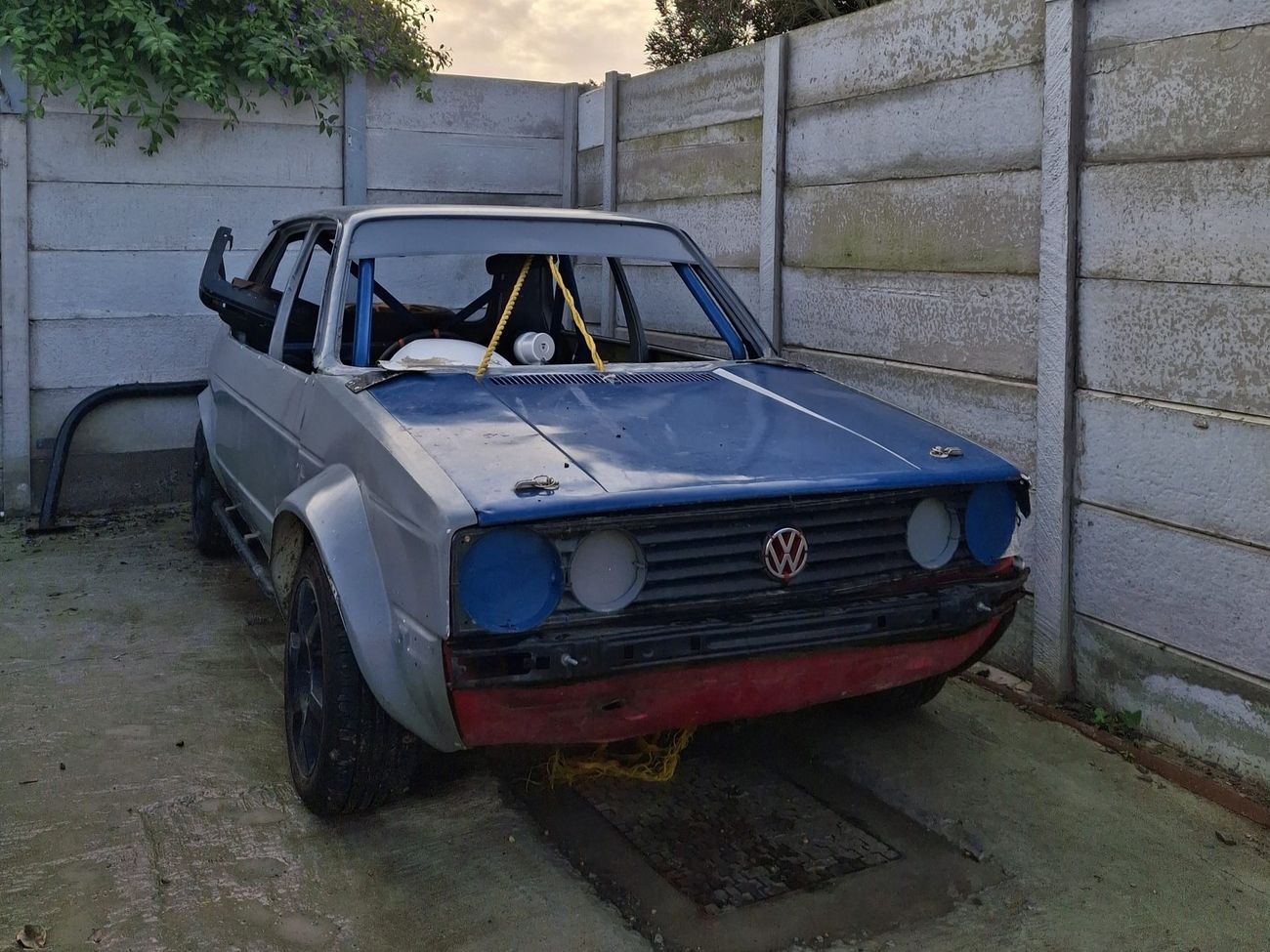 Golf stock car in bare metal and blue before respray